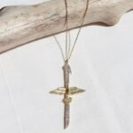 Elegante Elif Phönix Kette mit goldener Kette und schwertförmigem Anhänger mit Flügeln – Symbol für Wiedergeburt, Kraft und Transformation.